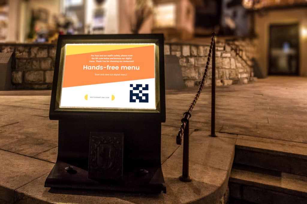 Digital signage display stand in front of restaurant with QR code for downloading digital menu